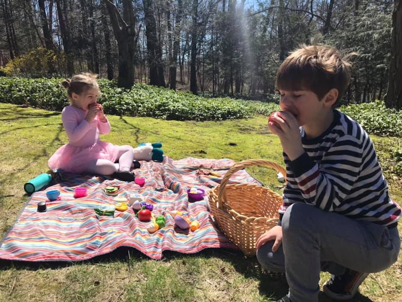 Two children enjoying a picnic outside. 