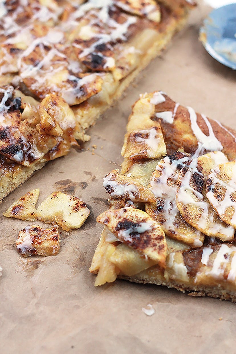 Thanksgiving sheet pan desserts, apple pumpkin dessert pizza squares with a glaze drizzle sitting on...