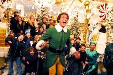 Buddy the Elf jumps and cheers while surrounded by kids in a holiday store in the Christmas movie, E...