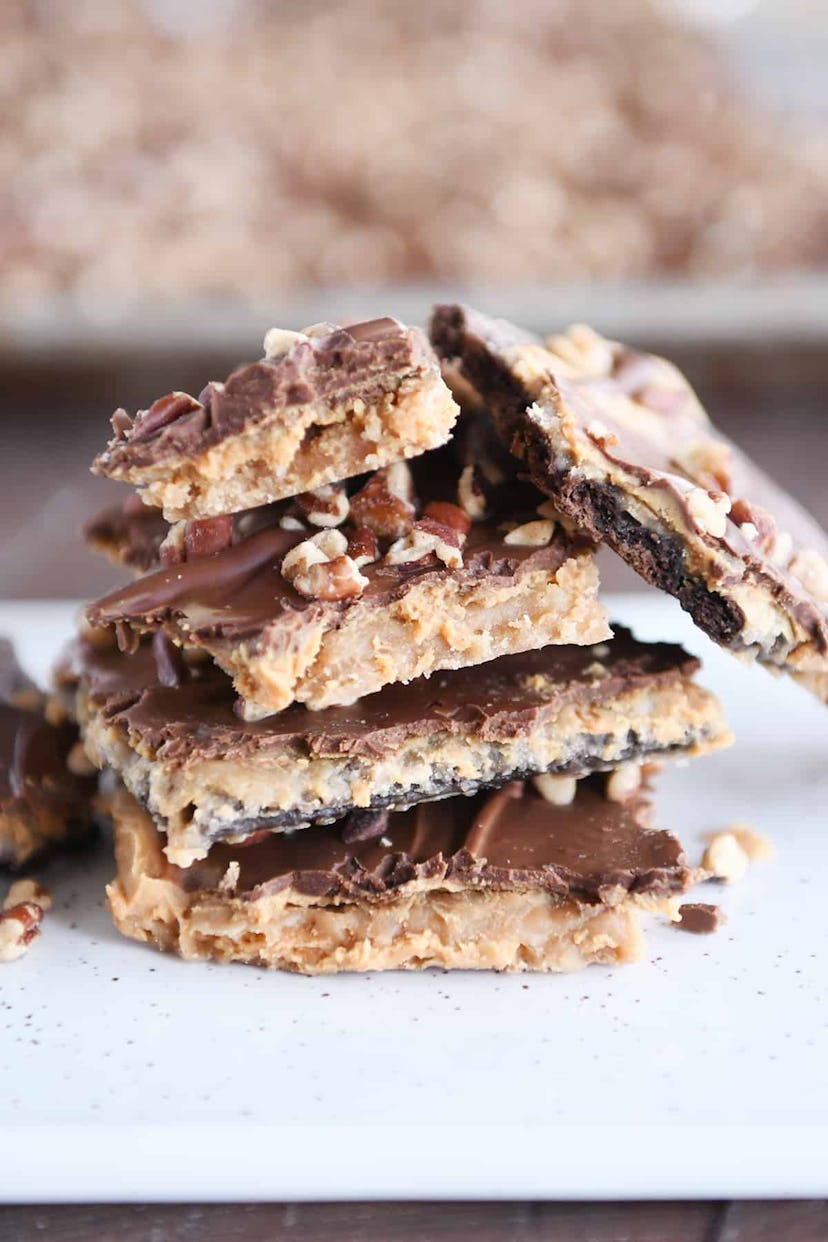 Thanksgiving sheet pan dessert, a stack of peanut butter chocolate graham cracker toffee squares pil...