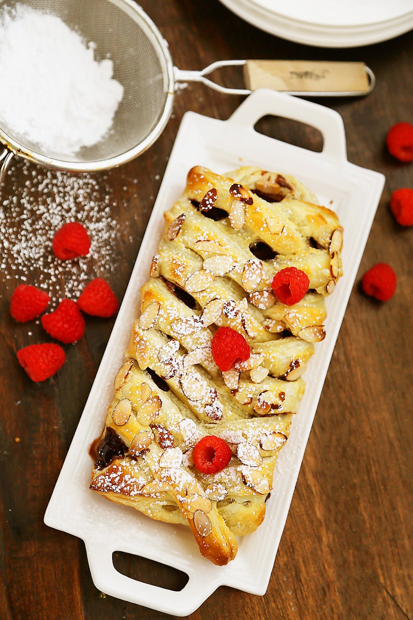 Thanksgiving sheet pan desserts, chocolate almond puff pastry braid with powdered sugar and raspberr...