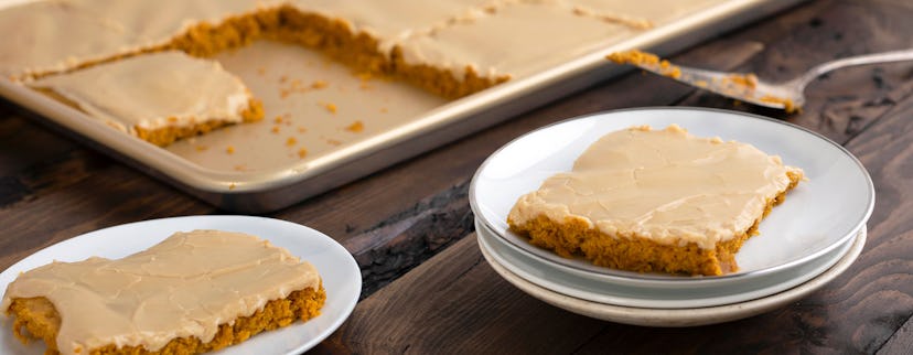 Thanksgiving sheet pan desserts, pumpkin sheet cake with brown sugar icing, cut into squares on shee...