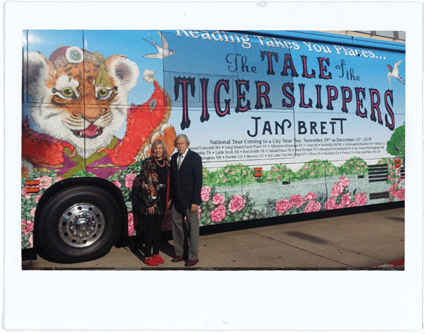 Jan Brett and her husband Joe Hearne stand in front of their tour bus