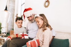 best holiday gifts for grandparents; grandpa opening christmas gifts with his grandkids 