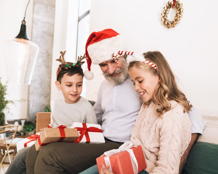 best holiday gifts for grandparents; grandpa opening christmas gifts with his grandkids 