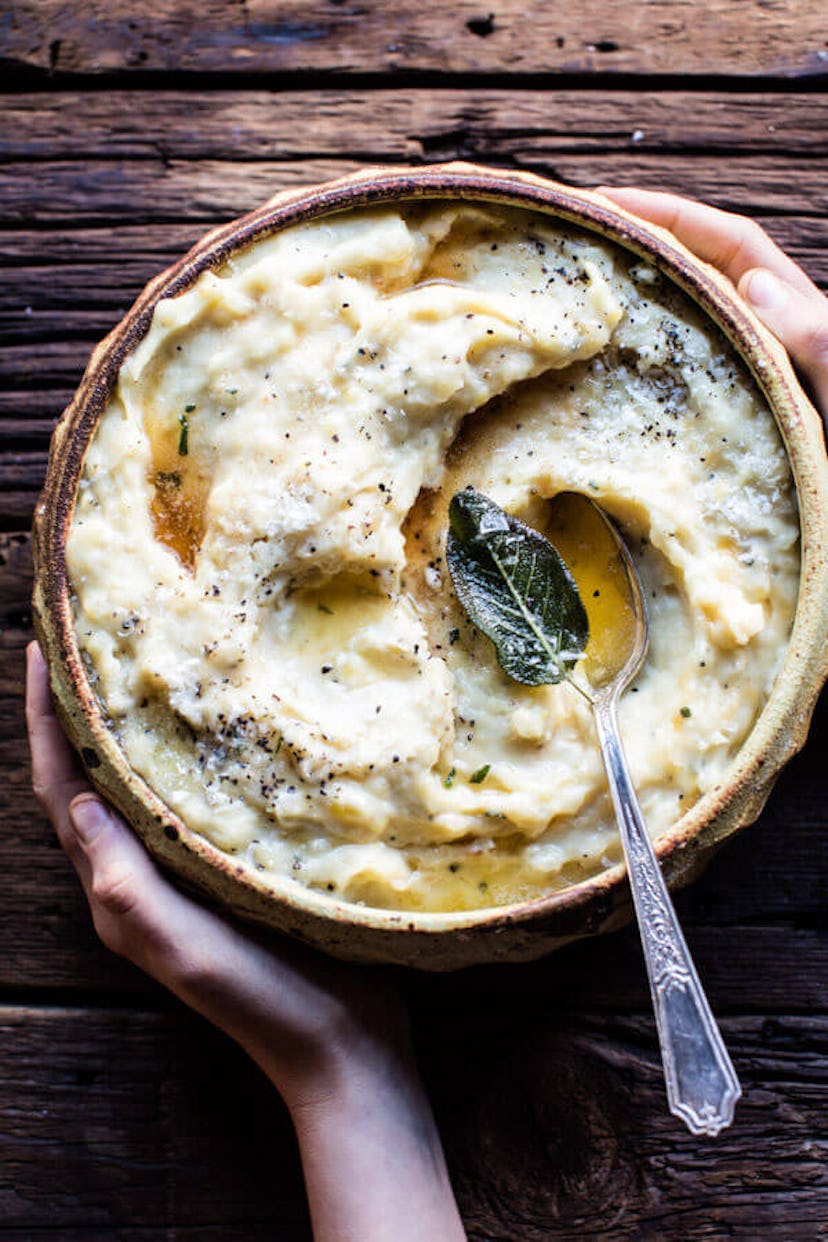 Bowl of mashed potatoes on table with a spoon in the bowl