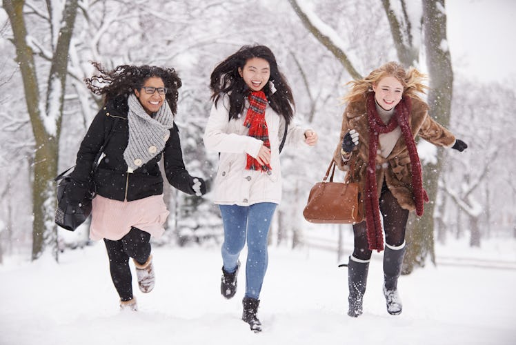 Three girl friends running in snow during Winter Solstice 2019