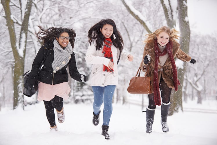 Three girl friends running in snow during Winter Solstice 2019