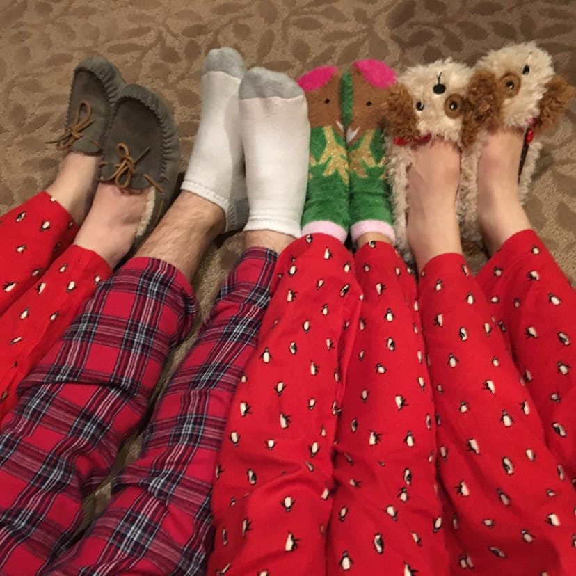 A family all in Christmas pajamas puts out their legs