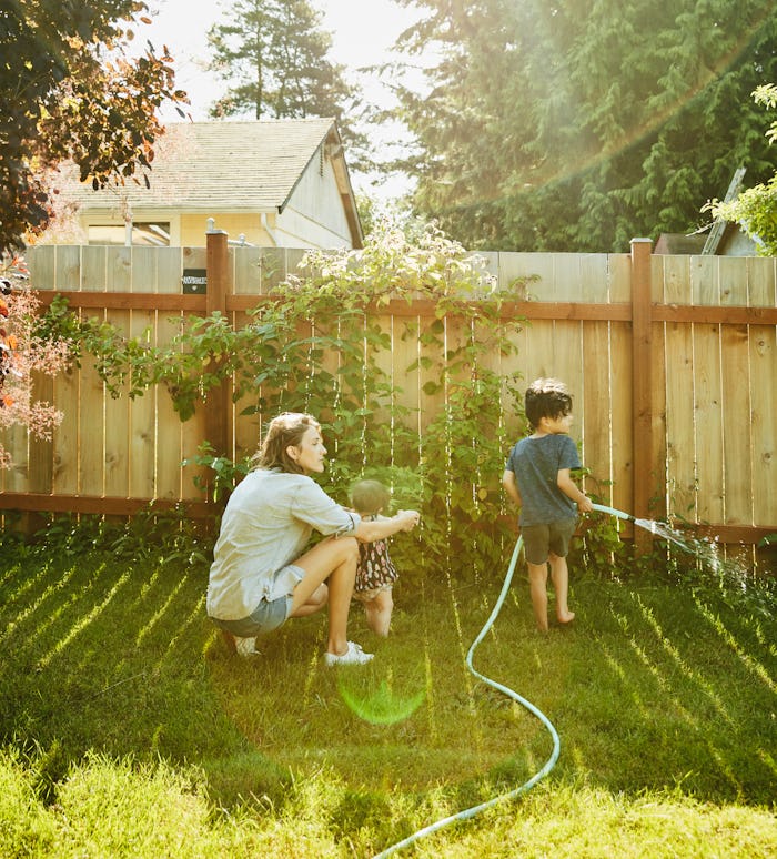 A mom waters the garden with her son