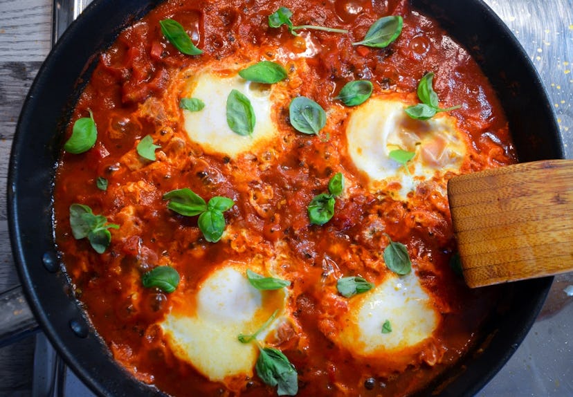 aerial shot of pan with poached eggs atop red sauce