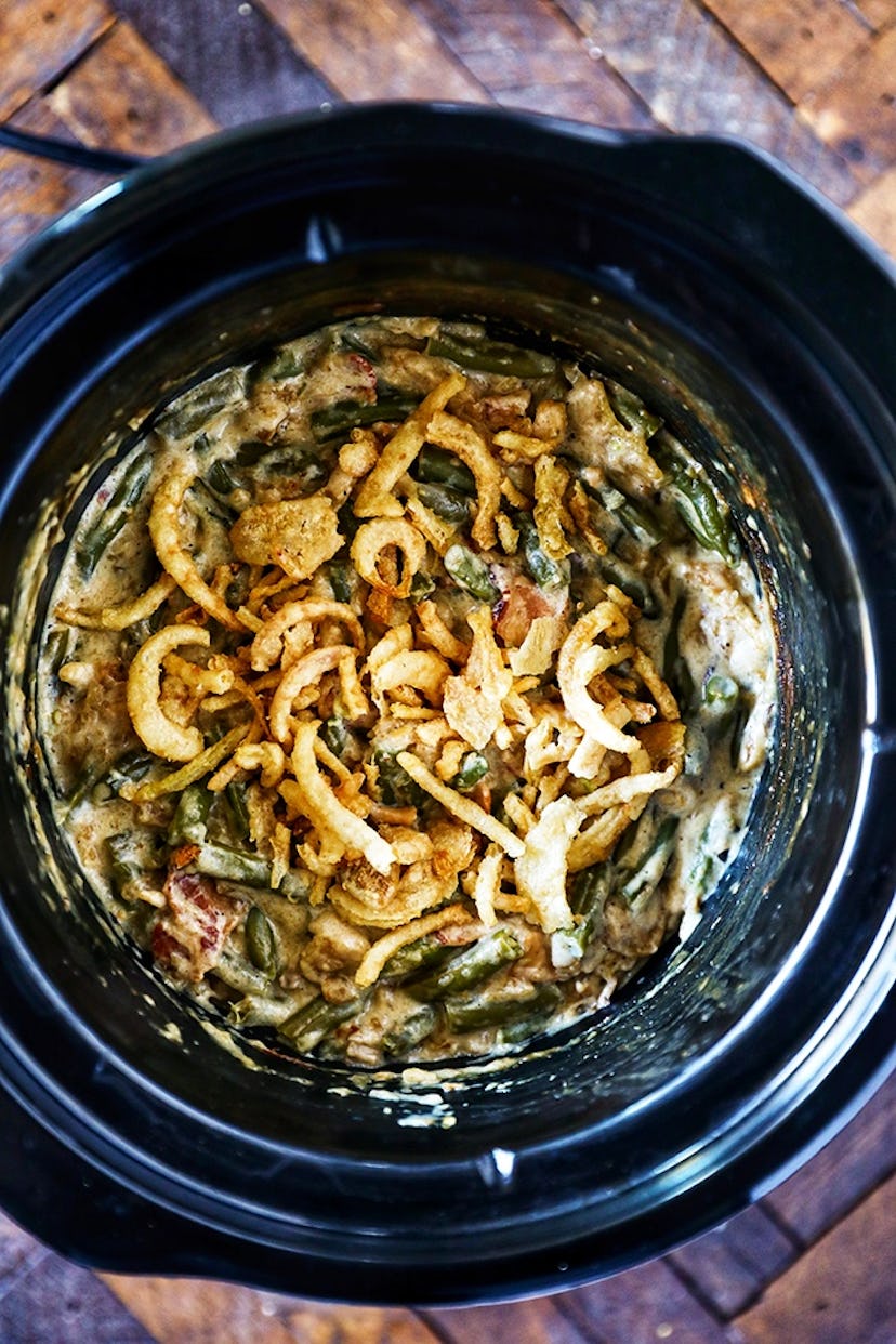Crock pot full of green bean casserole with fried onions on top