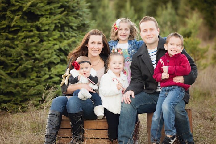 A family pose for their Christmas photo outside at a tree farm