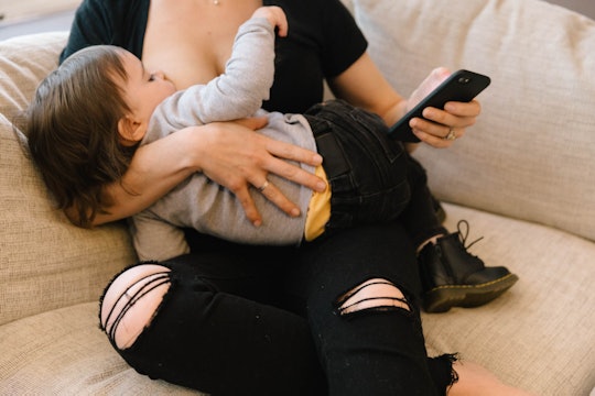 a mom breastfeeding her baby on a couch