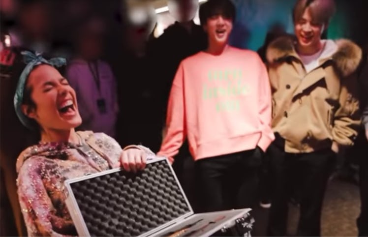 A screenshot from a video of BTS giving Halsey her Christmas gift.