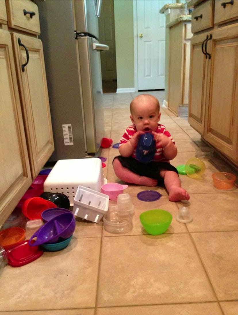 Letting your toddler play in your Tupperware cabinet is one way to keep your toddler busy while cook...