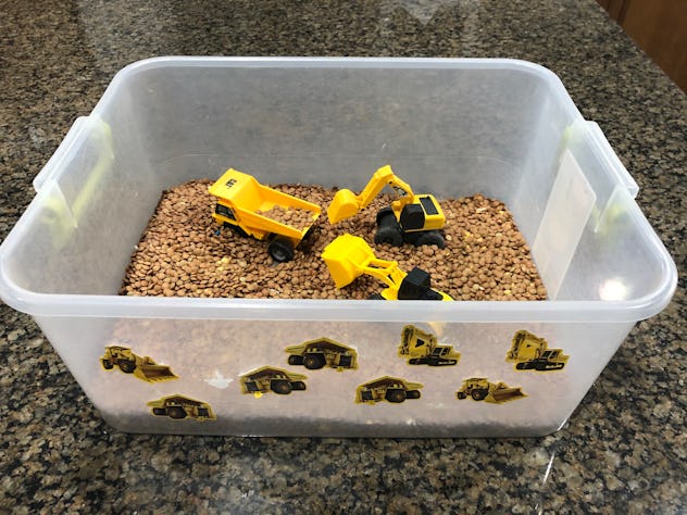 Playing in a busy box is one way to keep a toddler busy while cooking. 