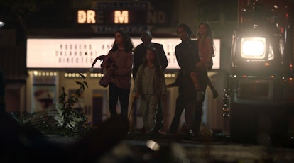 The Abar family walking in front of the Dr. M lights in the Dreamland Theater in Watchmen