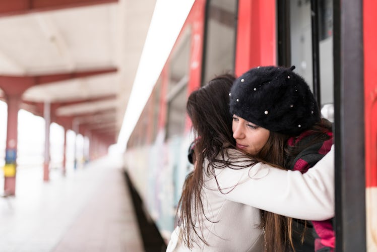 Lesbian couple hugging, missing each other over holidays