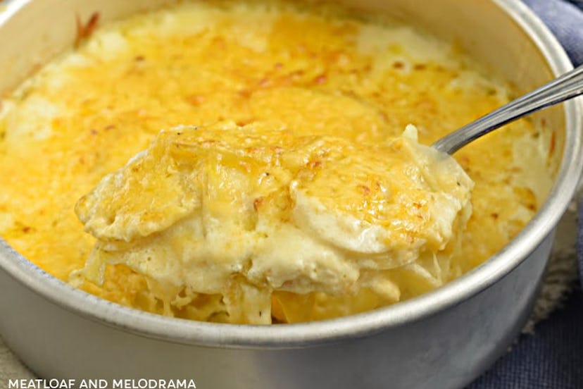 Pot of cheesy, scalloped potatoes being scooped out