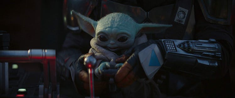 Baby Yoda happily looks at the buttons and switches of a spacecraft in 'The Mandalorian.'
