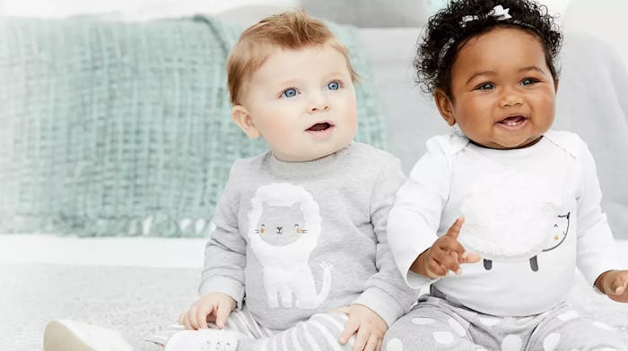 Two babies sitting next to each other in grey outfits as part of a Carter's sale ad