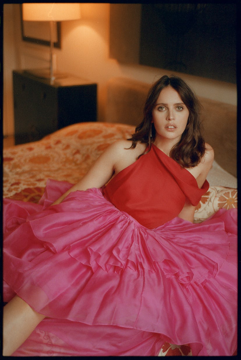 Felicity Jones wearing a red top and pink skirt combination by Greta Constantine in bed