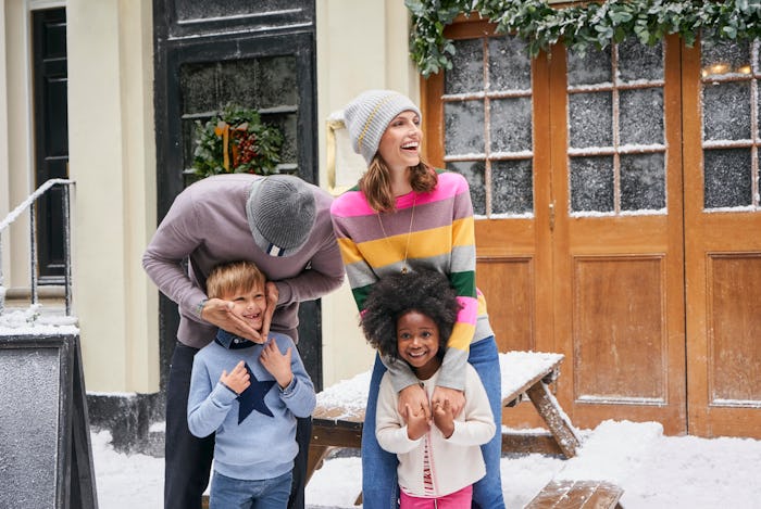 a man, woman, boy and girl wearing clothes from boden's holiday sale outside in the snow