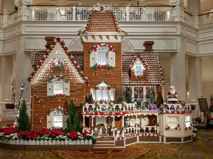 The giant gingerbread house decorated with poinsettia plans sits in the lobby of the Grand Floridian...