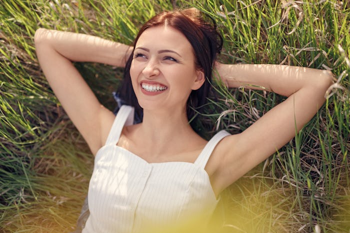 woman lying in field, looking at sky