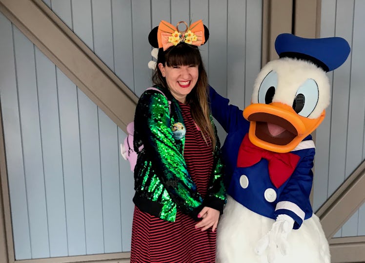 A woman stands next to Donald Duck at Disneyland on New Year's Eve. 