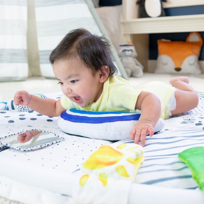 a baby playing on a sassy tummy time reversible milestone activity gym