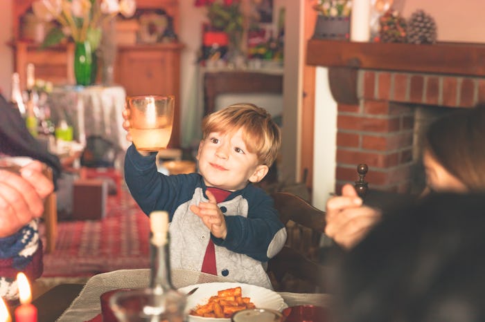 child raises glass to new year's eve