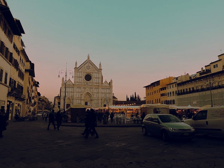 A Christmas market near the Basilica di Santa Croce in Florence is busy around sunset.