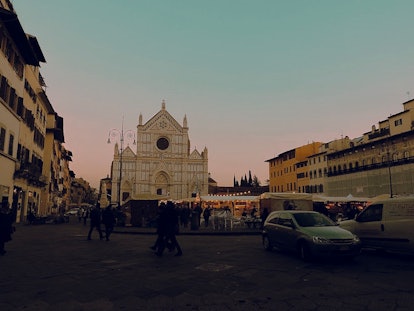 A Christmas market near the Basilica di Santa Croce in Florence is busy around sunset.