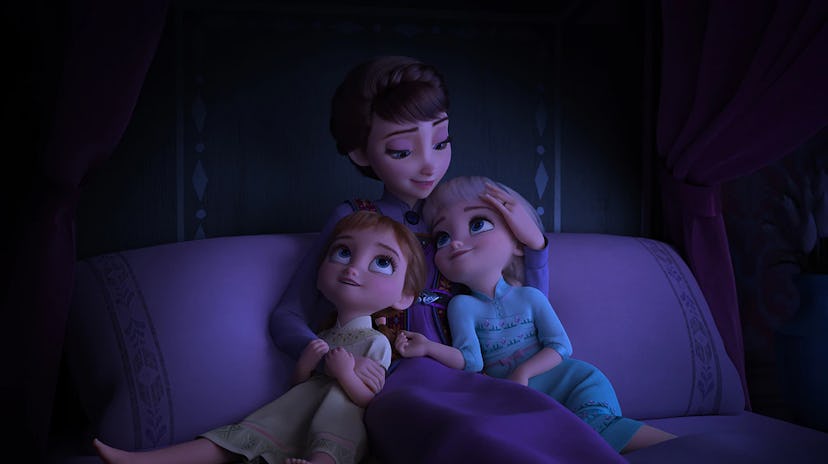 Anna and Elsa snuggle with their mother as children.