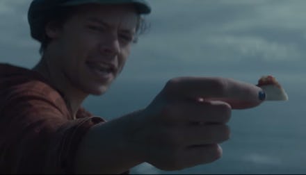 Harry Styles holds out a tiny taco for his fishy friend.