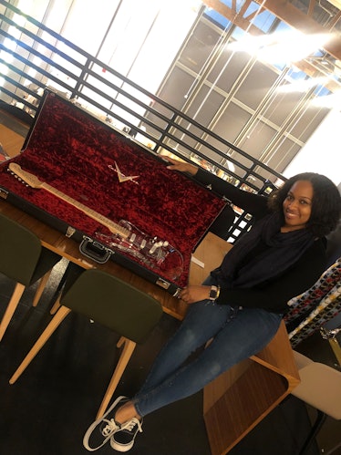 Moya Nkruma poses with a custom-made clear stratocaster guitar from Fender