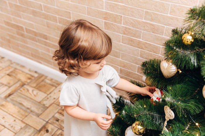 when is christmas 2019? toddler decorating a christmas tree 