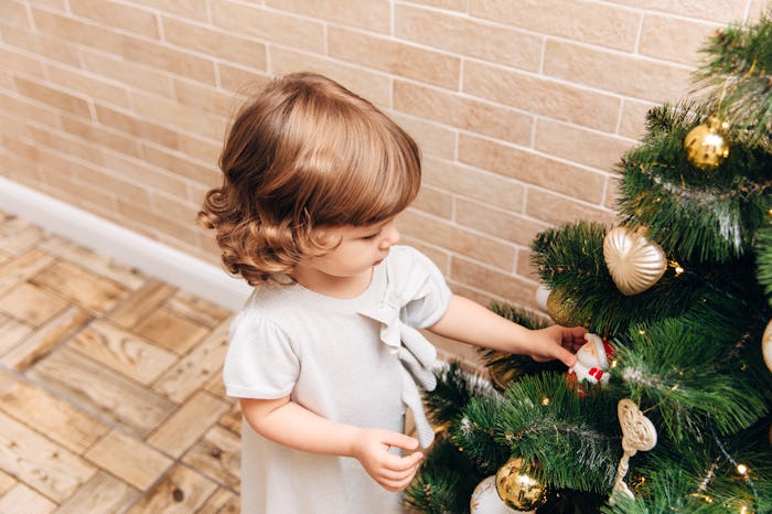 when is christmas 2019? toddler decorating a christmas tree