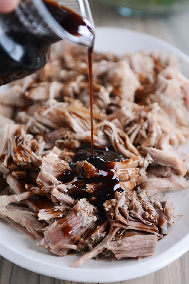 white plate of shredded pork with brown glaze pouring over top