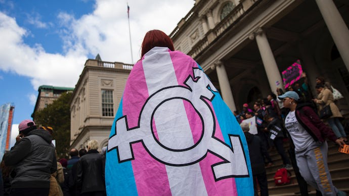 A woman wearing a trans flag on her back