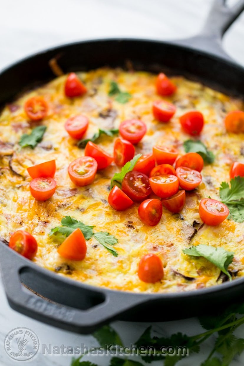 egg casserole topped with halved tomatoes in skillet