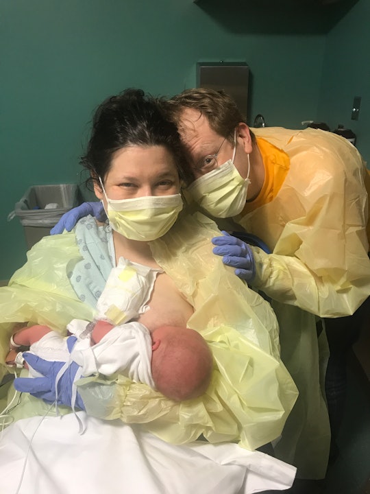 A woman who had PTSD after birth with her newborn child and partner in a hospital room