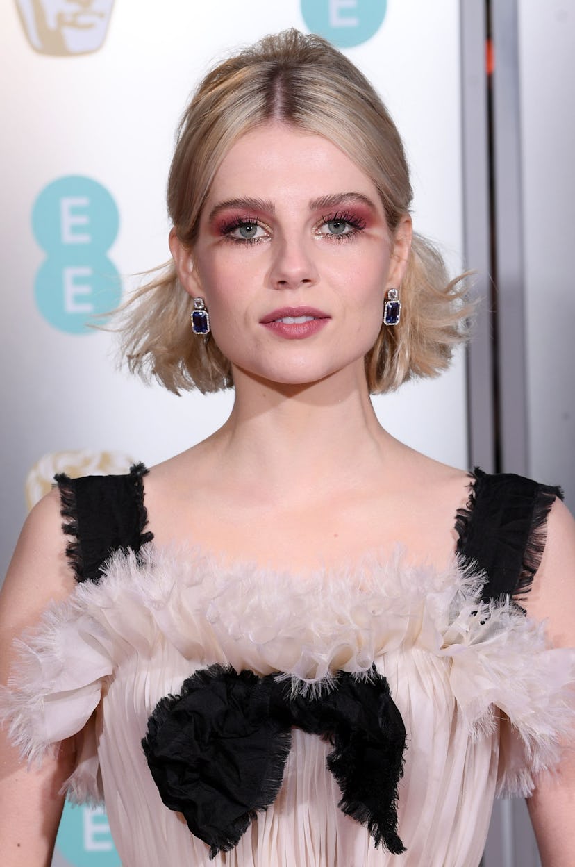 Lucy Boynton with a pink smoky eye and a matching lip, wearing a black and powder pink tulle dress a...