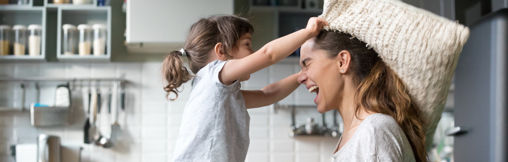 mom playing with daughter on couch