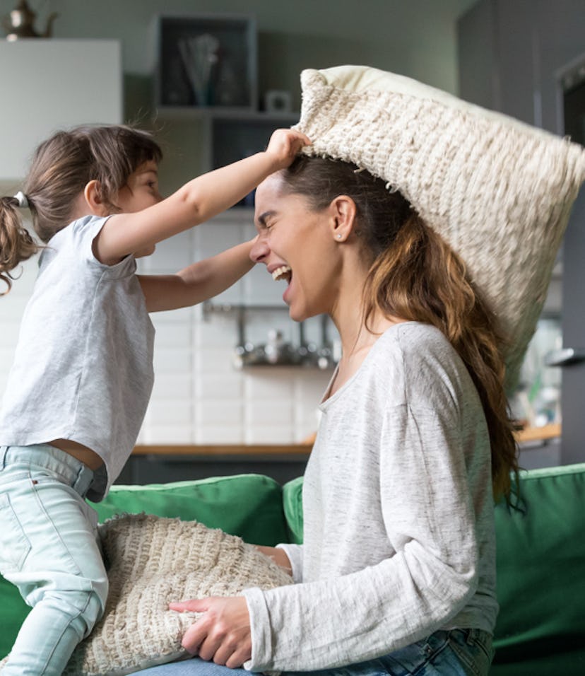 mom playing with daughter on couch