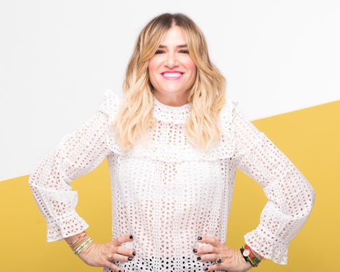 Drybar Founder Alli Webb posing in a sheer white shirt in front of a white and yellow background
