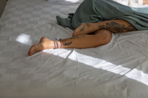 Women in bed experience period pain and cramps.