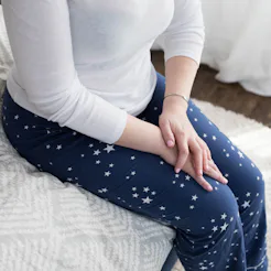 A lady nervously sitting at the edge of her couch due to social anxiety